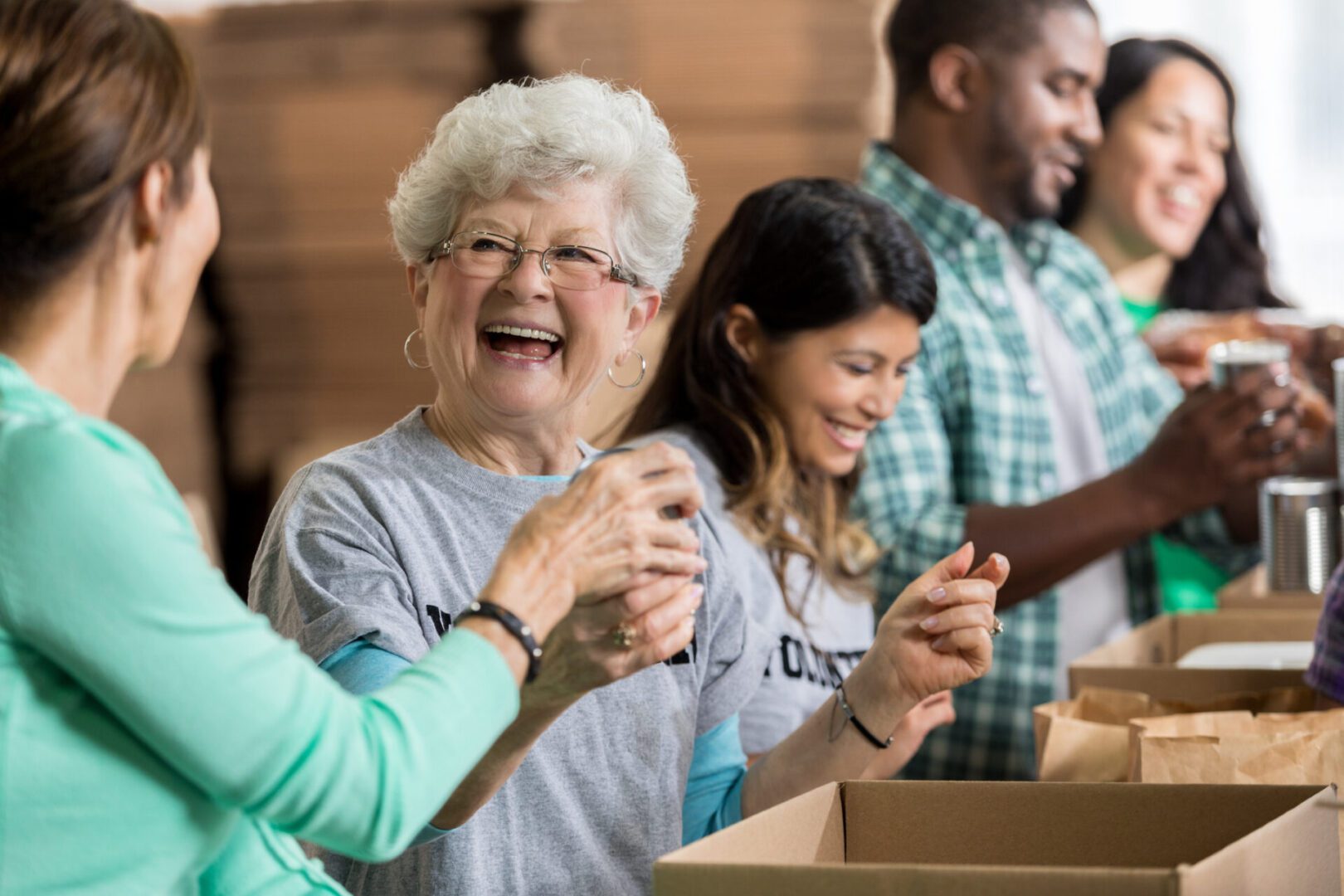 Happy volunteers packing boxes together.